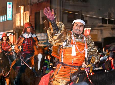 沿道の歓声に応える武田信玄役を務めた市川右団次さん（手前）＝４日夜、甲府市