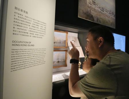 香港の歴史博物館で英国統治の歴史の説明文を読む親子＝５日（共同）