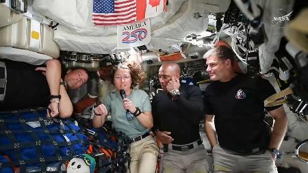 宇宙船オリオンから記者会見するクック飛行士（左から２人目）（ＮＡＳＡの中継から）