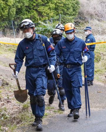 捜索現場の山林から出る京都府警の警察官=9日午後、京都府南丹市