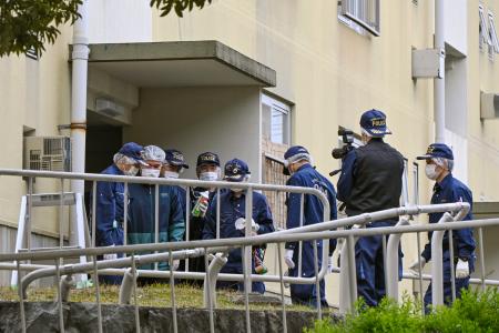 　集合住宅の入り口付近で現場検証をする大阪府警の捜査員＝９日午前１１時５１分、大阪府和泉市