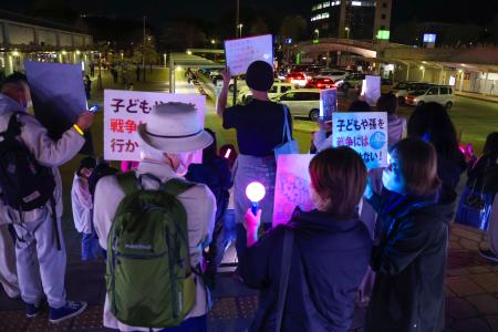 戦争反対などを訴えるポスターを手にした参加者＝８日、茨城県つくば市