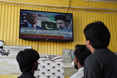 米イラン協議について伝える地元テレビ放送を見つめるパキスタンの市民=10日、イスラマバード(ロイター=共同)