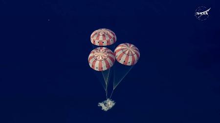 　パラシュートを開き、米西部カリフォルニア州沖に着水する宇宙船オリオン＝１０日（ＮＡＳＡの中継から）