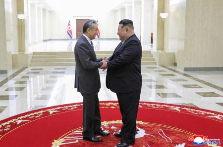 訪朝した中国の王毅外相（左）と握手する北朝鮮の金正恩朝鮮労働党総書記＝１０日、平壌（朝鮮中央通信＝共同）