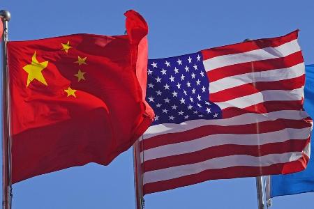 掲げられた中国国旗（左）と米国国旗＝２０２５年１２月、北京（共同）
