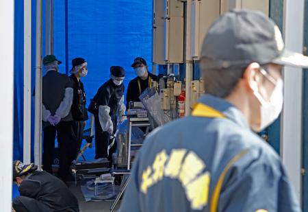 　姫野忠文容疑者の自宅周辺を調べる大分県警の捜査員＝１２日午前９時５９分、大分市