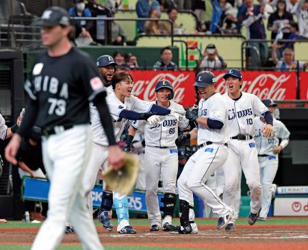 １０回、サヨナラ本塁打を放ちチームメートに迎えられる西武・林安可（右から２人目）。手前は打たれたロッテのロング＝ベルーナドーム