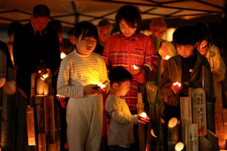熊本地震の「前震」から１０年となり、発生時刻に黙とうする子どもら＝１４日午後９時２６分、熊本県益城町