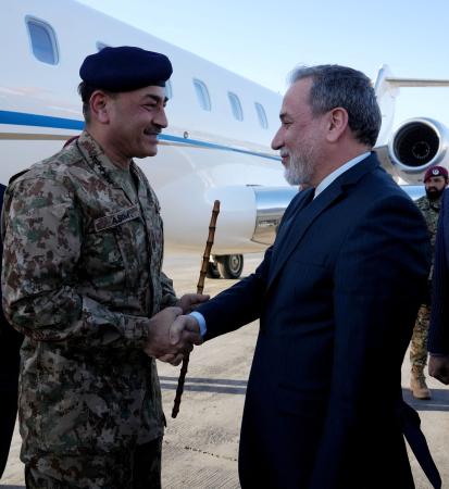 １５日、イランの首都テヘランの空港で、アラグチ外相（右）に迎えられるパキスタンのムニール陸軍元帥（ロイター＝共同）