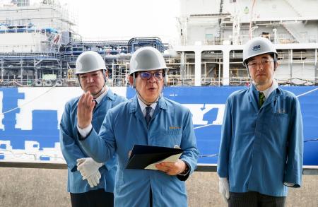 建造中の大型アンモニア燃料船を視察し、記者団の取材に応じる金子国交相（中央）＝１９日午後、熊本県長洲町
