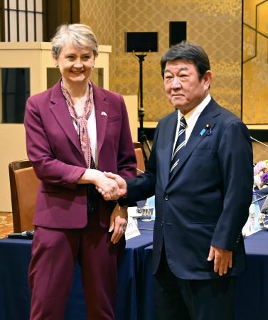 英国のクーパー外相（左）と握手する茂木外相＝２０日午後、東京都内