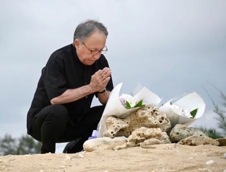　沖縄県名護市辺野古沖での転覆事故の現場を臨む「瀬嵩の浜」で手を合わせる玉城デニー知事＝２１日午後