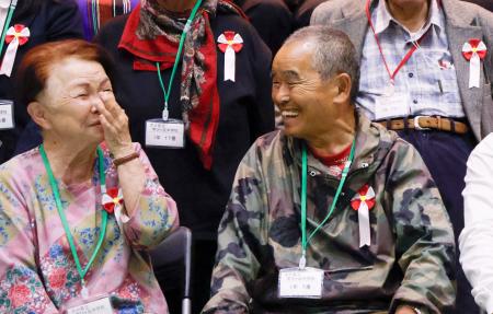 　大分県立学びケ丘中の入学式を終え、他の新入生らと談笑する尾畠春夫さん（右）＝２１日午後、大分市