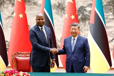 調印式で握手する中国の習近平国家主席（右）とモザンビークのチャポ大統領＝２１日、北京の人民大会堂（共同）