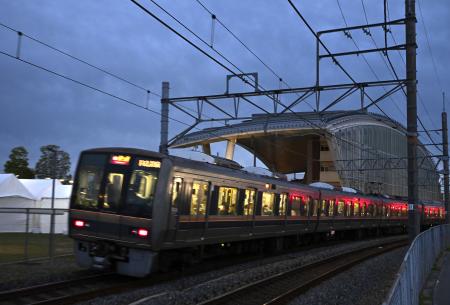 　尼崎ＪＲ脱線事故の現場に整備された「祈りの杜」の横を通過する電車＝２４日午後、兵庫県尼崎市