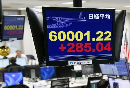 一時６万円台を回復した日経平均株価を示すモニター＝２７日午前、東京都港区の外為どっとコム