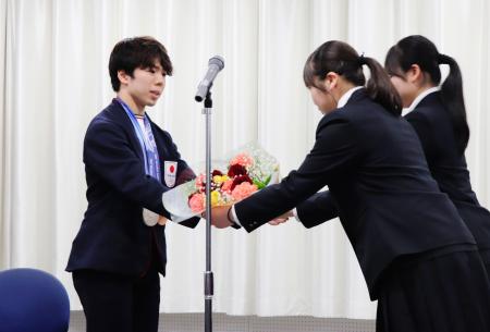 母校の埼玉栄高でミラノ・コルティナ冬季五輪の報告会を行い、花束を贈られるフィギュアスケート男子の佐藤駿＝２７日、さいたま市