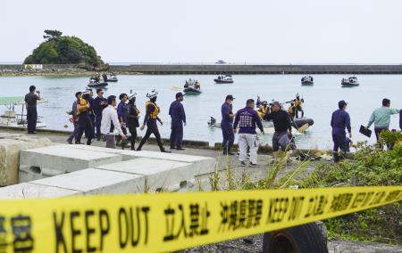船が転覆した事故現場近くの港で作業する海上保安庁の職員ら＝３月１６日、沖縄県名護市辺野古