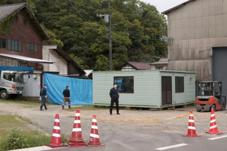 　男性の遺体が土の中に埋められているのが見つかった現場周辺を警戒する広島県警の捜査員ら＝２９日午後６時２６分、広島県三原市