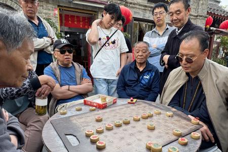 路上で中国将棋（シャンチー）をする人たち＝４月、北京（共同）