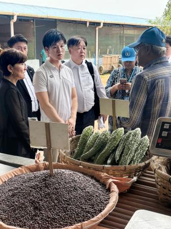 関係者からロヒンギャ難民キャンプの食事情の説明を受ける鈴木農相（手前左から２人目）＝３０日、バングラデシュ・コックスバザール（共同）