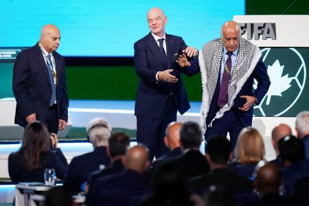ＦＩＦＡの総会で壇上から立ち去るパレスチナ協会のラジューブ会長（右）。左はイスラエルの代表、中央はＦＩＦＡのインファンティノ会長＝４月３０日、バンクーバー（ＡＰ＝共同）