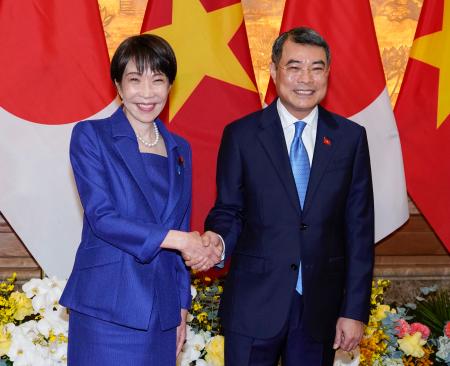 会談を前に、ベトナムのレ・ミン・フン首相（右）と握手する高市首相＝２日、ハノイ（共同）