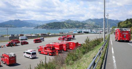 消防車両が並ぶ岩手県大槌町の港。山林火災の鎮圧が発表された＝２日午前