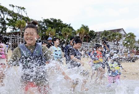 水しぶきを上げて海に入る子どもたち＝４月、鹿児島県・奄美大島