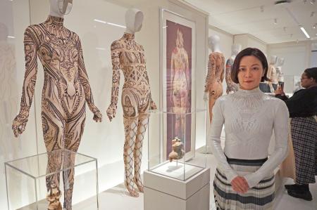 「コスチューム・アート展」で、自らの作品(左2点)のそばに立つ廣川玉枝さん=4日、米ニューヨークのメトロポリタン美術館(共同)