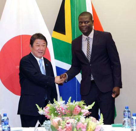 南アフリカのラモラ国際関係・協力相(右)と握手を交わす茂木外相=5日、プレトリア(共同)