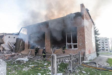 ロシア軍の空爆後、消火活動に当たる消防隊員ら=5日、ウクライナ東部ドネツク州(ゲッティ=共同)