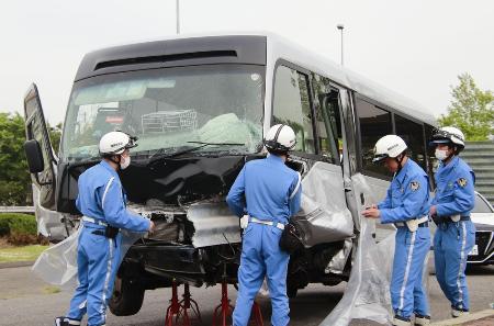 　マイクロバスにビニールをかける警察官ら＝６日午後、福島県郡山市