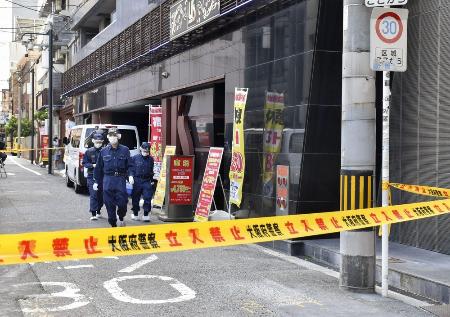 女性の遺体が見つかった現場付近を調べる大阪府警の捜査員=9日、大阪市中央区