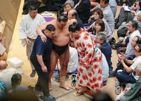 高安に敗れ、土俵下で付け人らの肩を借りる豊昇龍＝両国国技館