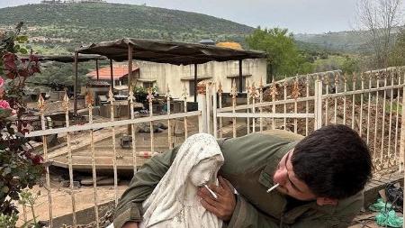 聖母マリア像にたばこを押しつけるイスラエル軍の兵士（ソーシャルメディアから、ロイター＝共同）