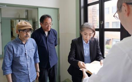 京都大吉田寮「現棟」の建て替え方針撤回などを求め、声明文を提出する駒込武教授(奥中央)ら=14日午後、京都市左京区