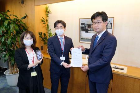 厚労省の仁木博文副大臣（右）に要望書を提出する「全国コロナ後遺症患者と家族の会」の担当者＝１４日午後、厚労省