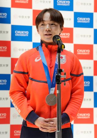中京大で開かれたミラノ五輪報告会であいさつする鍵山優真＝１５日、名古屋市