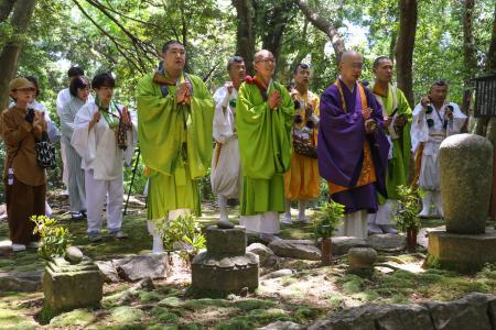 補陀洛山寺の裏山にある「渡海上人」の墓前で読経する僧侶たち＝１７日午後、和歌山県那智勝浦町