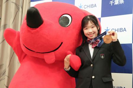 ミラノ・コルティナ冬季五輪の銅メダルを掲げ、千葉県の公式キャラクター「チーバくん」と写真に納まる中井亜美選手=19日午前、千葉県庁