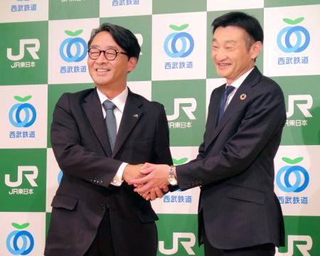 記者会見で握手するＪＲ東日本の喜勢陽一社長（左）と西武鉄道の小川周一郎社長＝１９日午後、東京都内