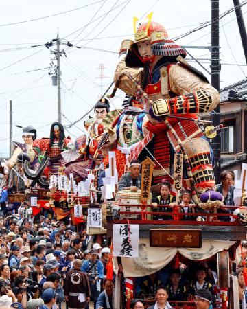 北陸三大祭りの一つとして知られる「三国祭」で、源義経（手前）などの巨大な武者人形を載せて町中を巡行する山車＝２０日午後、福井県坂井市