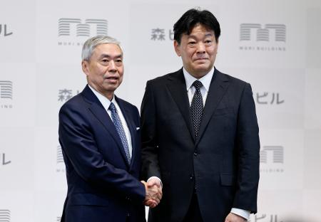 森ビル社長交代の記者会見を終え、握手する辻慎吾社長（左）と向後康弘氏＝２０日午後、東京都港区