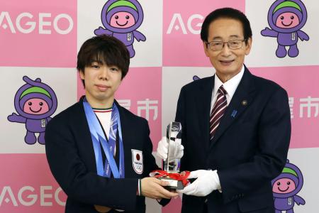 埼玉県上尾市の畠山稔市長（右）から市栄誉賞のトロフィーを受け取るフィギュアスケートの佐藤駿選手＝２２日午前、上尾市役所