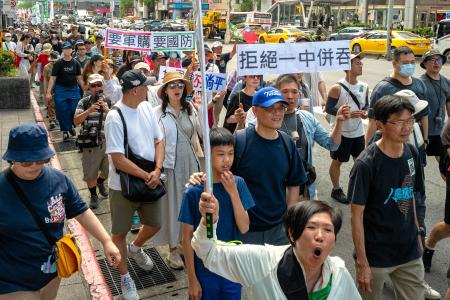 　２３日、台北市の繁華街を行進するデモ参加者ら（共同）