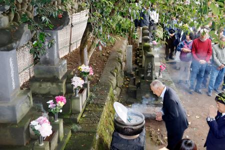 　小栗まつりで、群馬県高崎市にある墓に手を合わせる人たち＝２４日午後