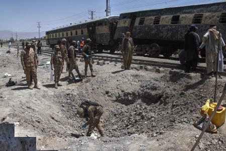 パキスタン南西部で24日に発生した爆発の現場を調べる軍関係者ら(AP=共同)