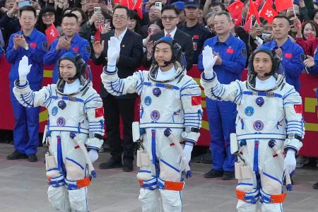 中国の有人宇宙船「神舟２３号」の打ち上げに臨む乗組員の（左から）黎家盈氏、張志遠氏、朱楊柱氏＝２４日、酒泉衛星発射センター（共同）